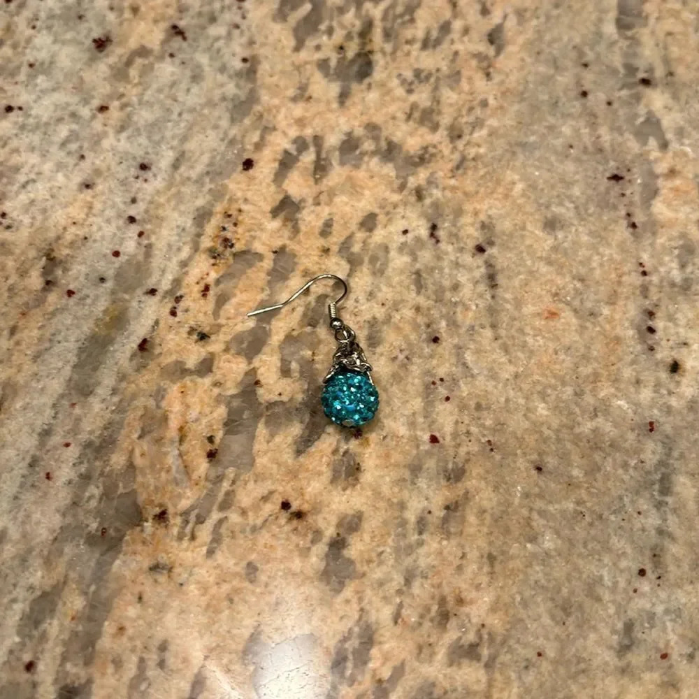 Woman's one sparkly blue dangling earring